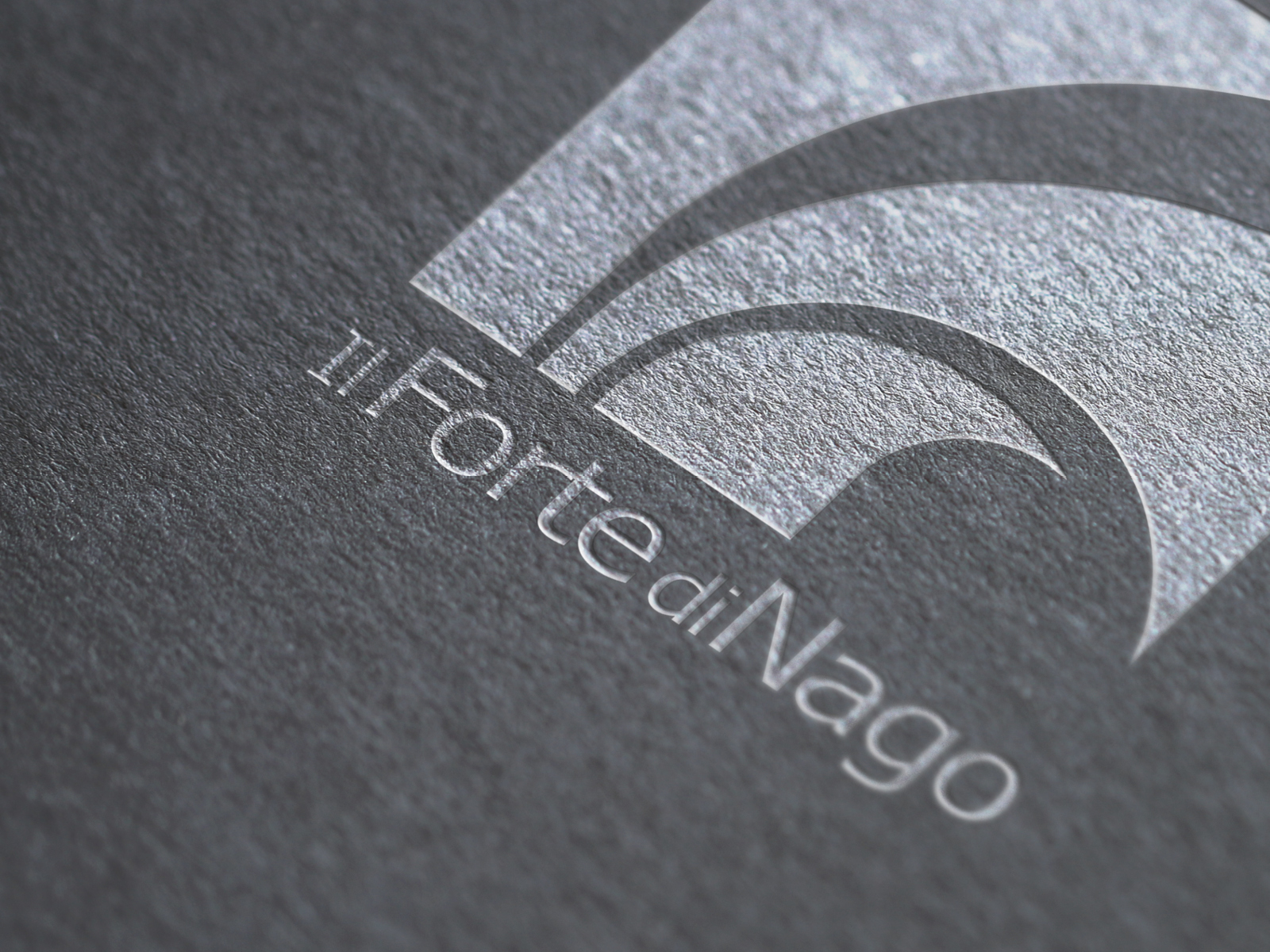 particolare del logo del forte di nago stampato su carta materica in colore bianco, progettato dalla agenzia diadestudio di arco trento